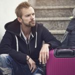 müder Mann mit Reisegepäck